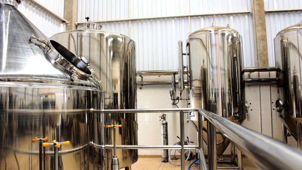 Stainless steel processing tanks in a food and beverage production facility